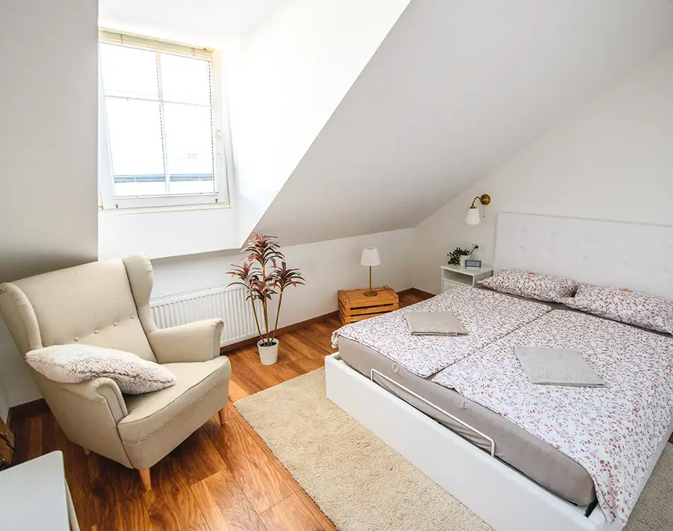 Laminat Trends für 2025 schlafzimmer mit bett und sessel sowie rustikalem laminat