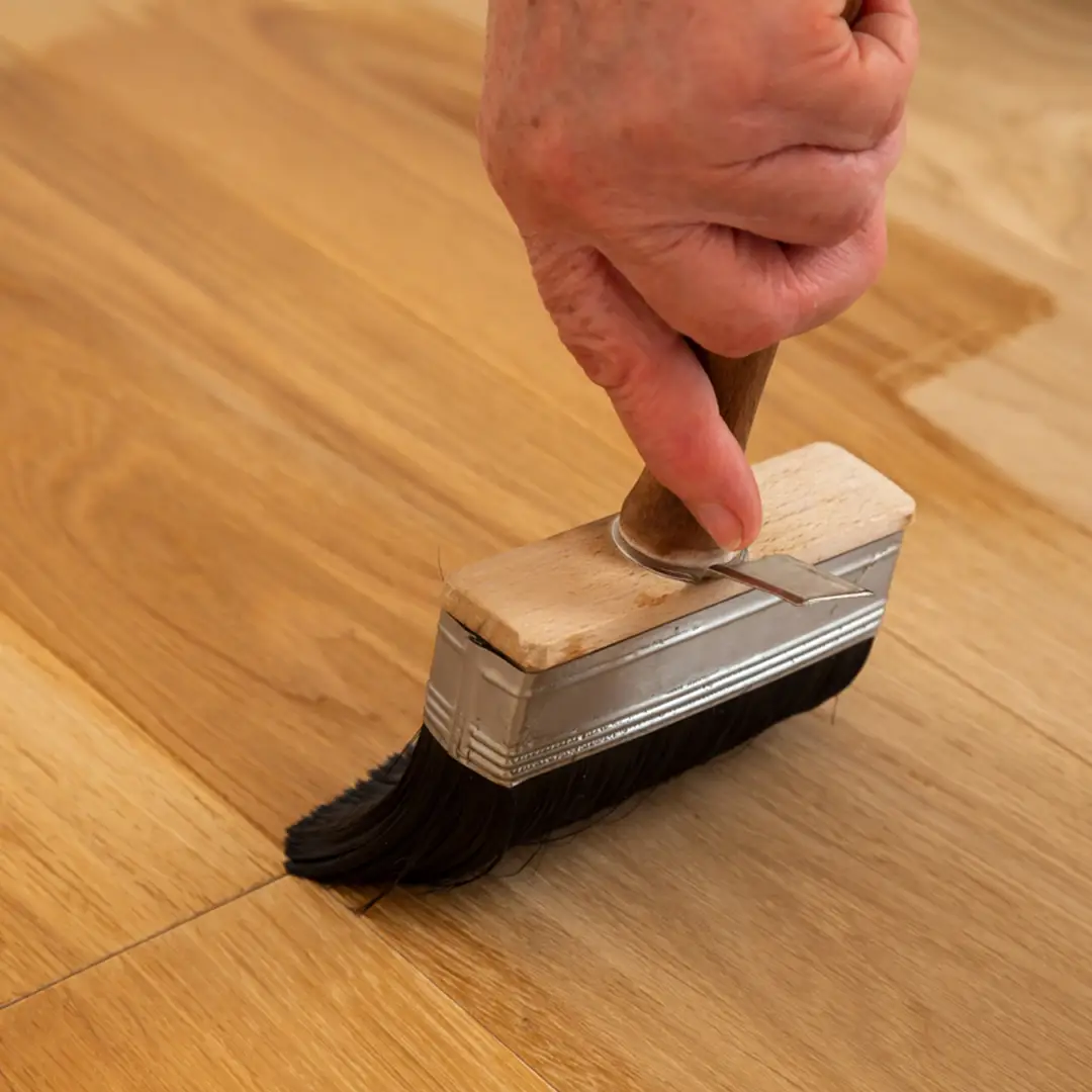 Zubehoer Pflege Osmo geoeltes Parkett mit Pinsel wird das Parkett geoelt