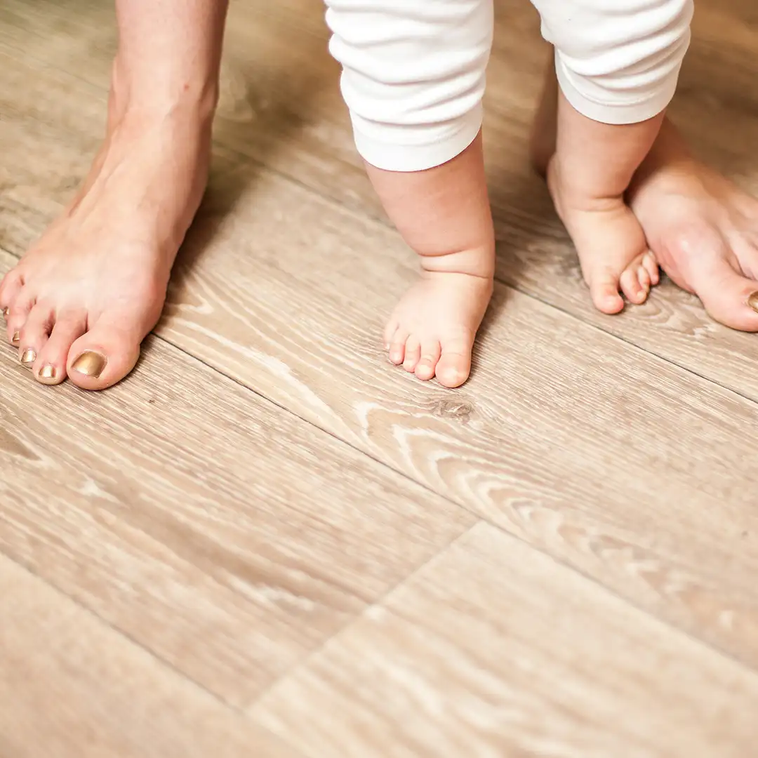 Nachhaltigkeit und Energieeffizienz: Worauf es bei der Auswahl von Bodenbelägen im Neubau ankommt füße von einem kleinen baby und einer erwachsenen person nahaufnahme